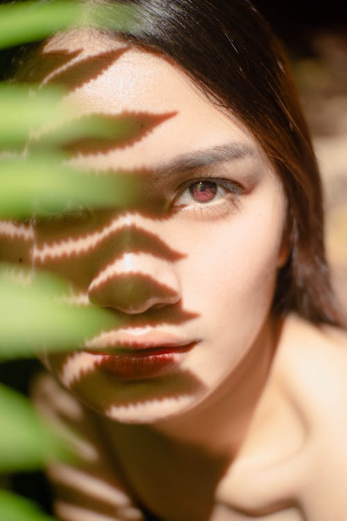 Calm woman with shadow from green leaf