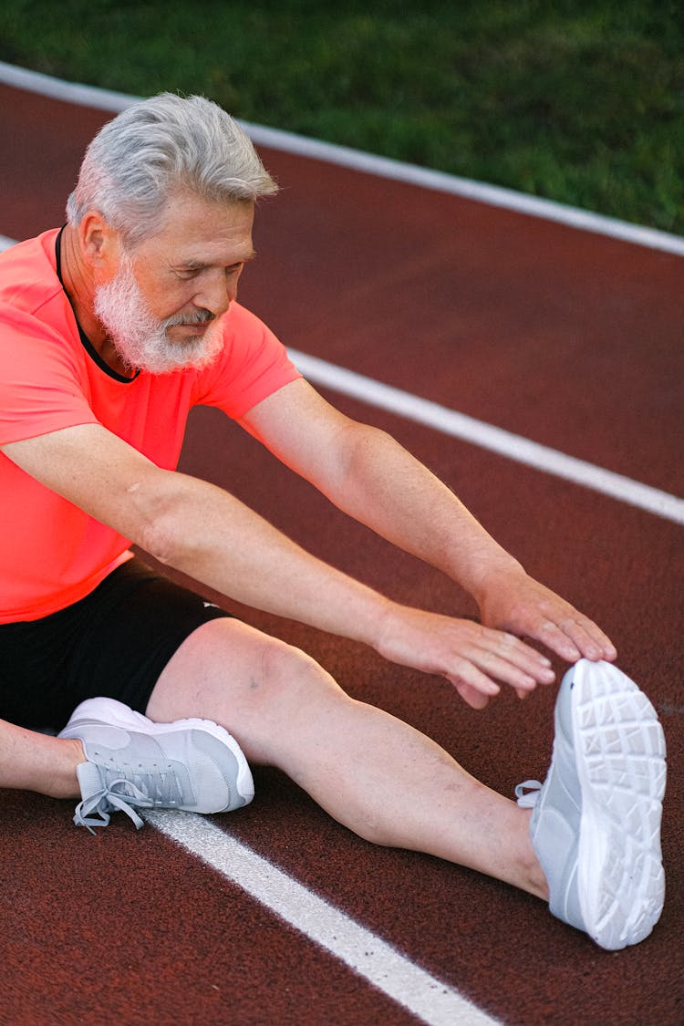 Strong Senior Man Stretching On Track