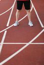 Man in sneakers and shorts standing on racetrack