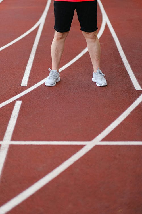 Free Man in sneakers and shorts standing on racetrack Stock Photo