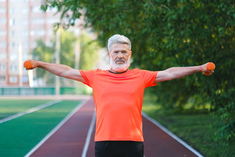 Sporty Elderly Man Training With Dumbbells