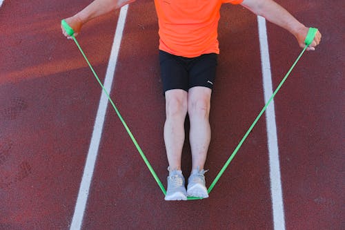 Sportsman training with resistance band on street