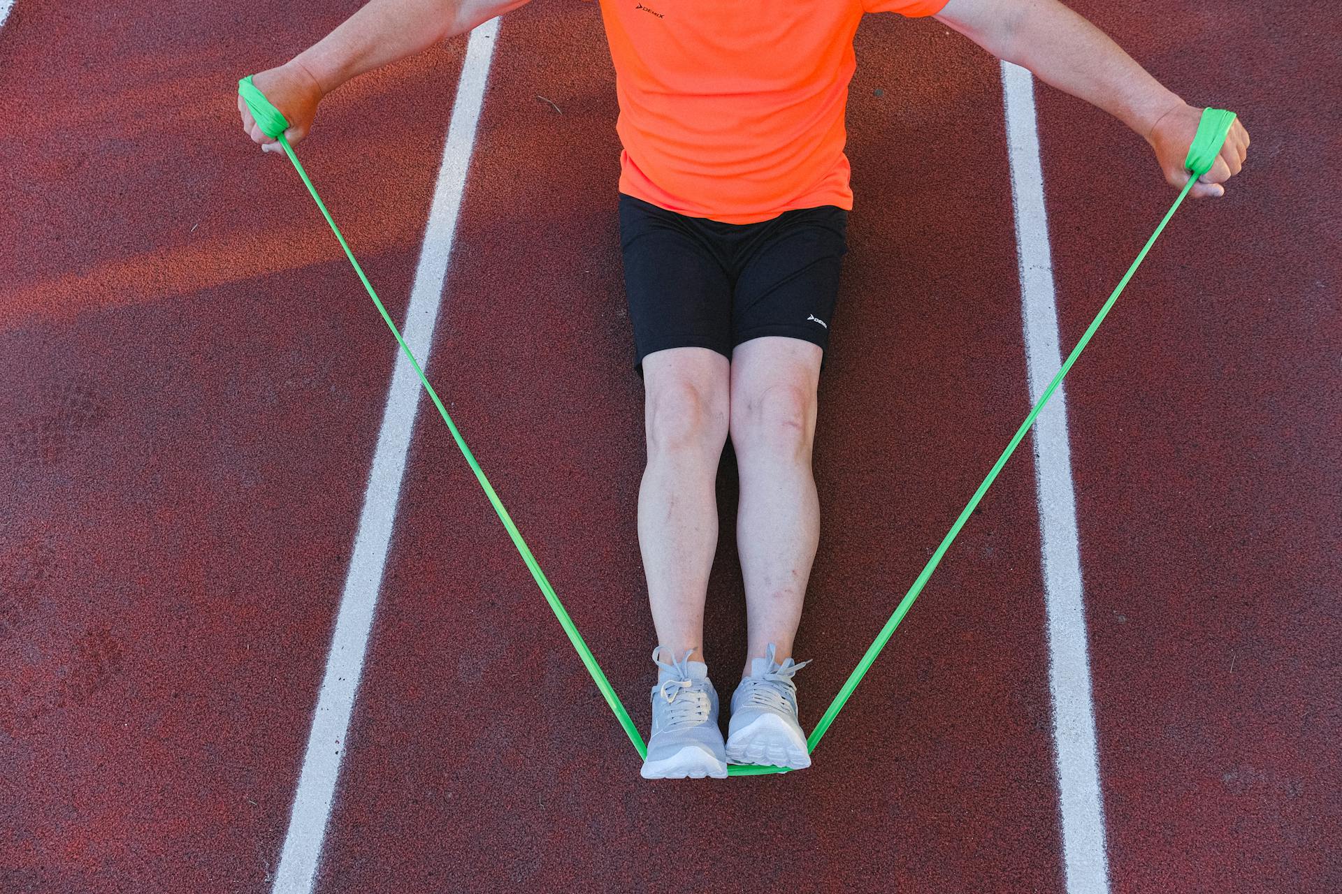 Sportsman training with resistance band on street