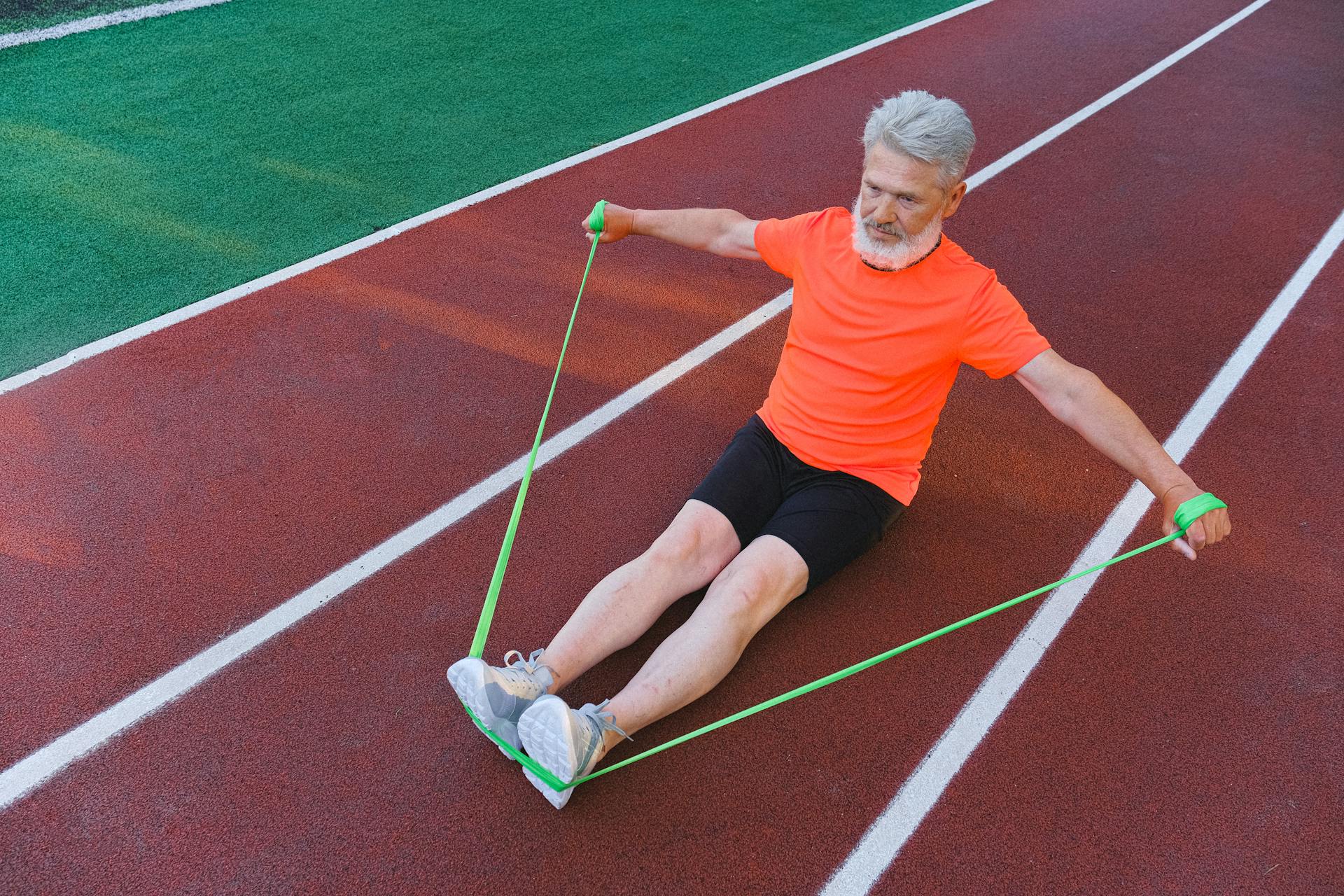 Focused aged man doing exercise with strap elastic