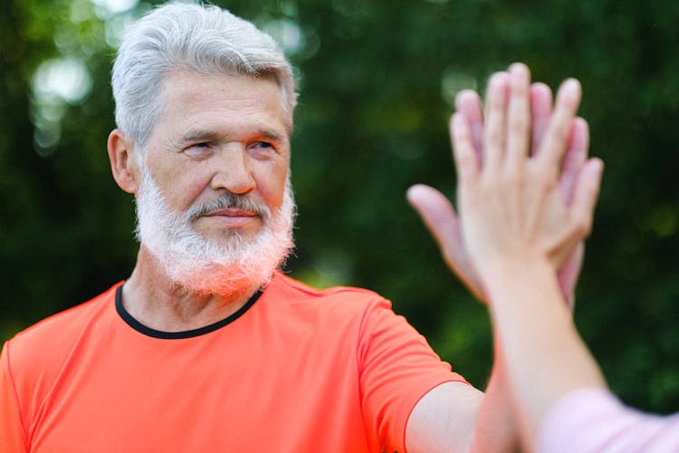 Pensive Aged Man Giving High Five To Friend