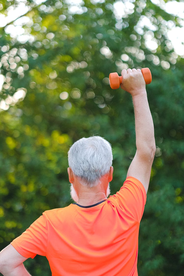 Strong Aged Sportsman Training With Dumbbells