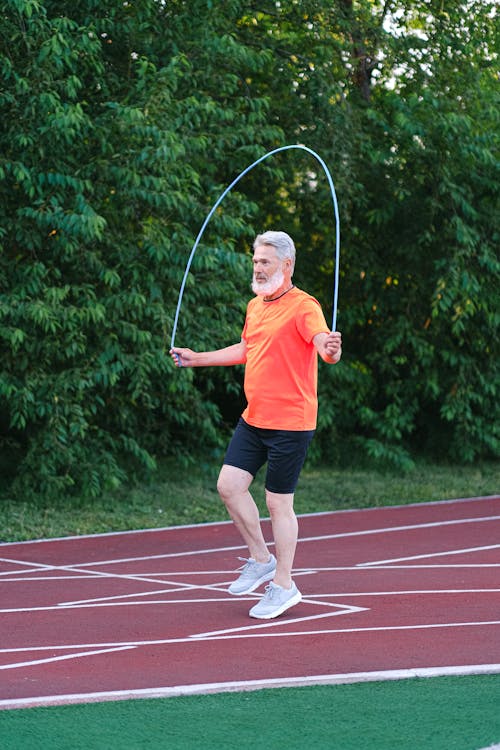 Senior sportsman training with jump rope on stadium · Free Stock Photo