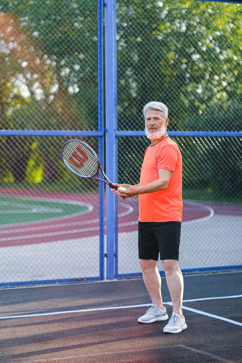 Experienced player in sportswear holding a racket and ball