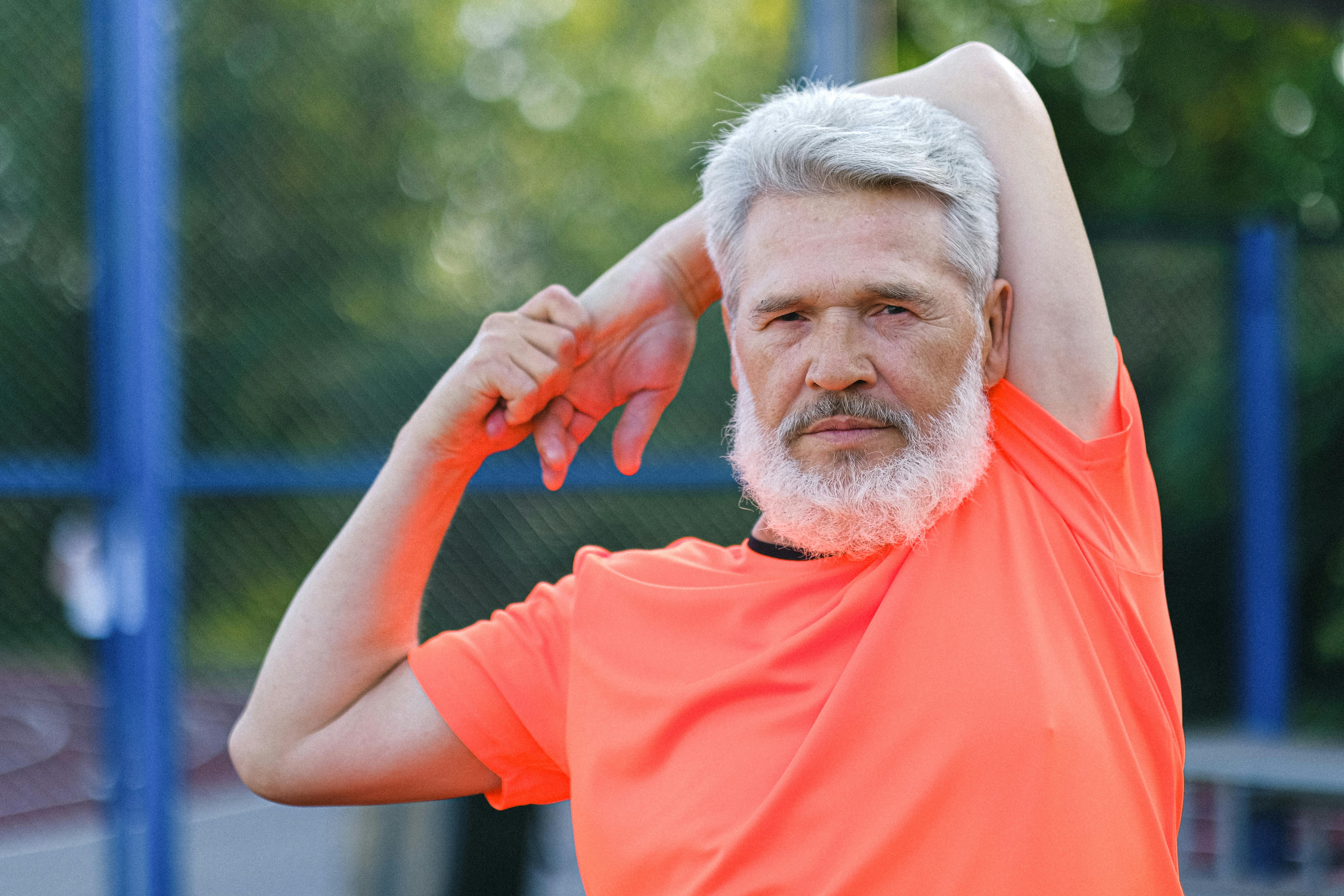 serious mature man stretching on stadium