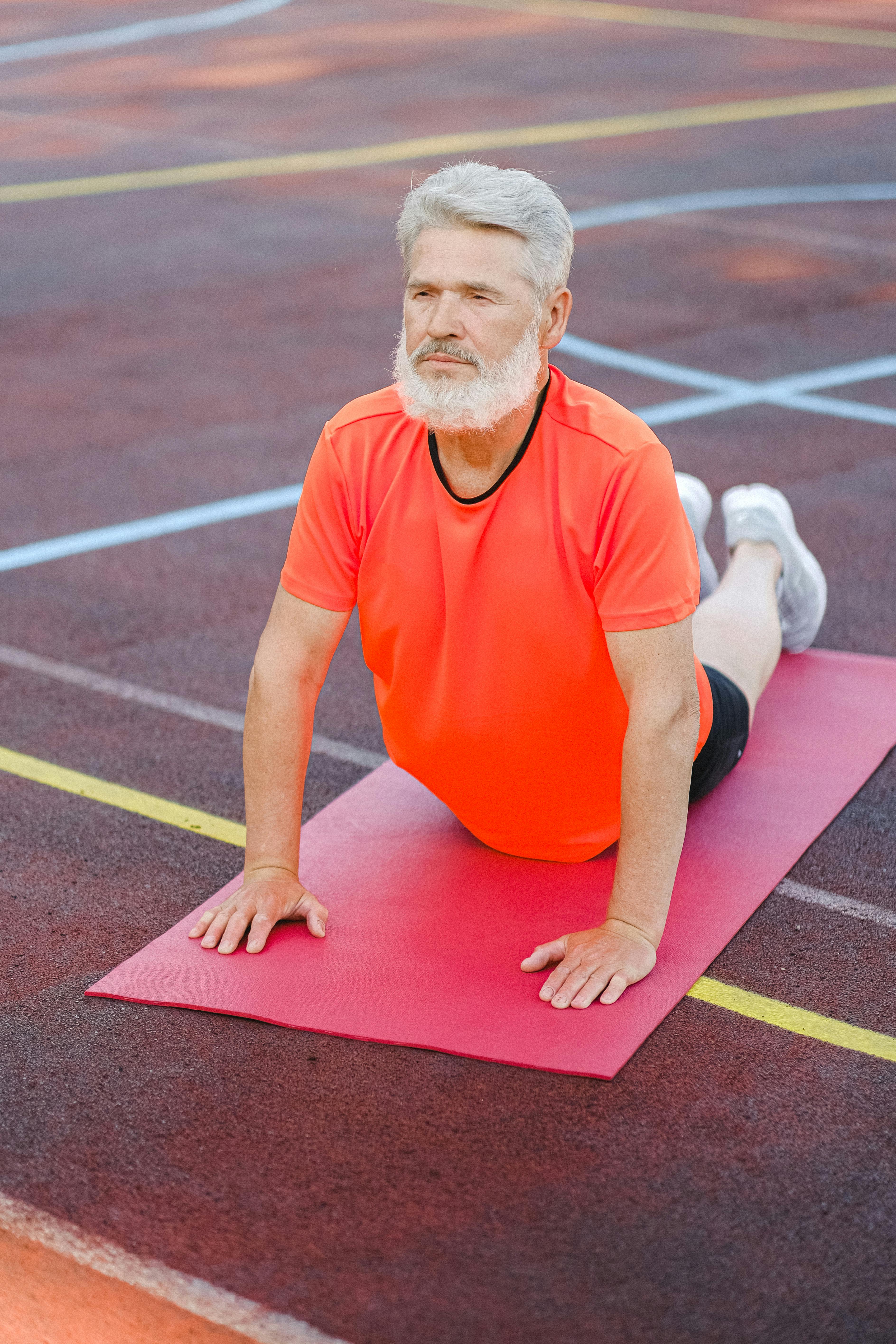 mature man stretching body on fitness mat