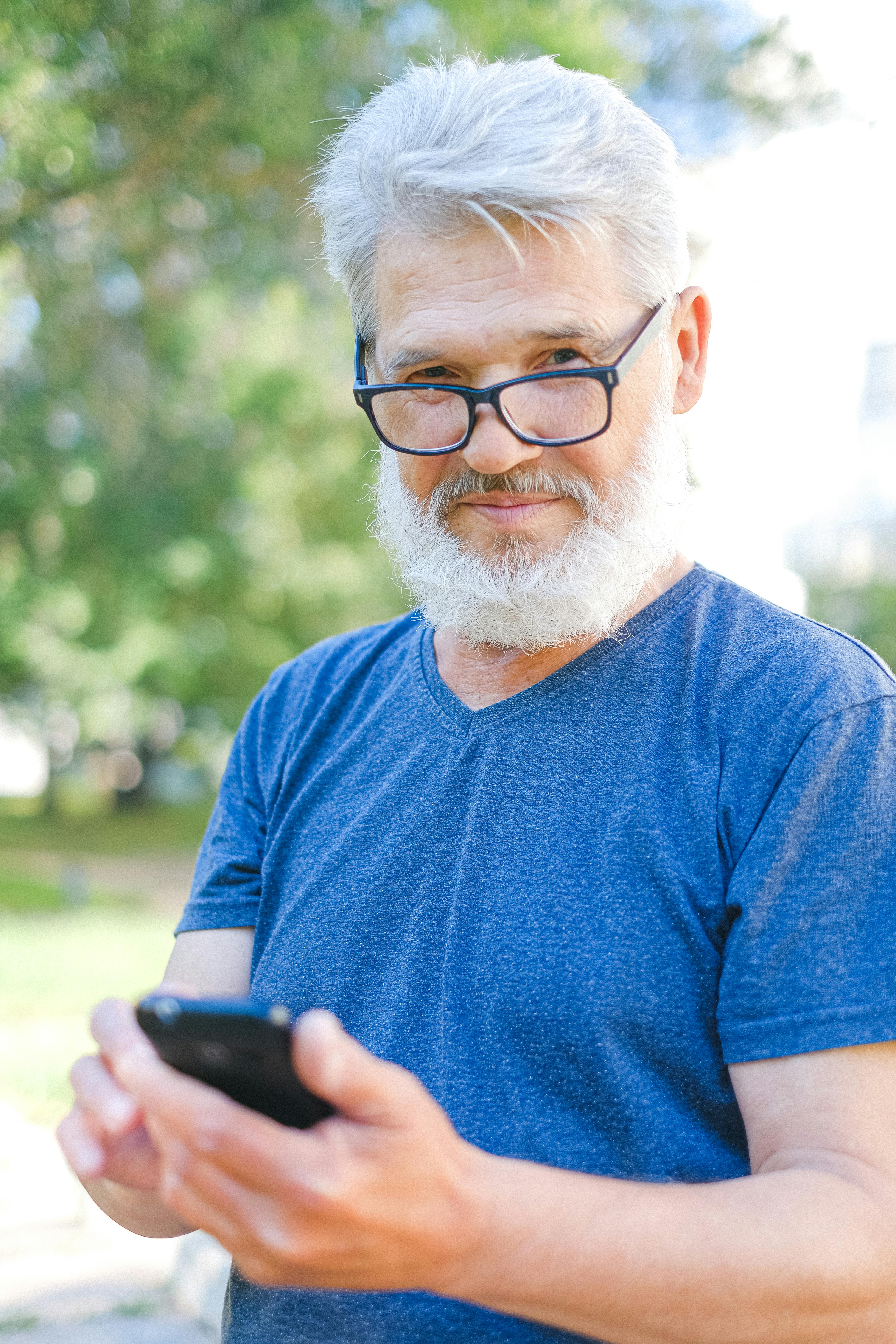 mature man using smartphone while walking