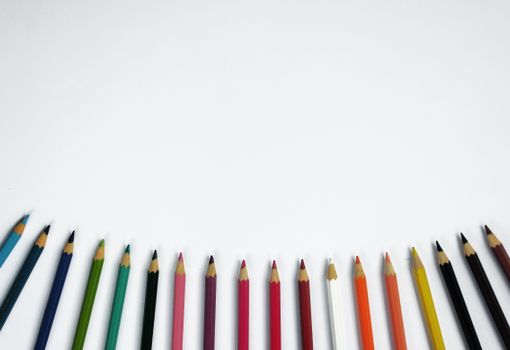 A vibrant array of colored pencils arranged on a white surface, perfect for creative and educational purposes.