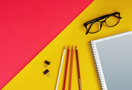 Black Framed Eyeglasses Near the Notebook