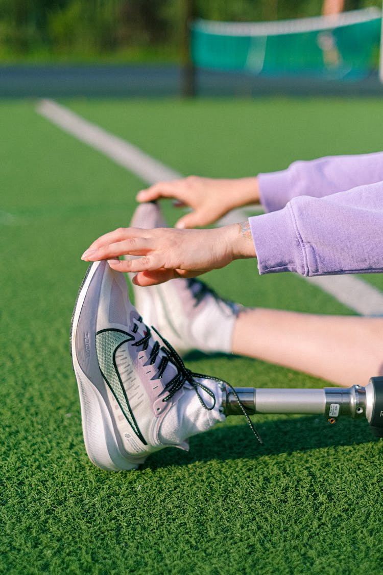 Crop Disabled Woman Stretching On Stadium