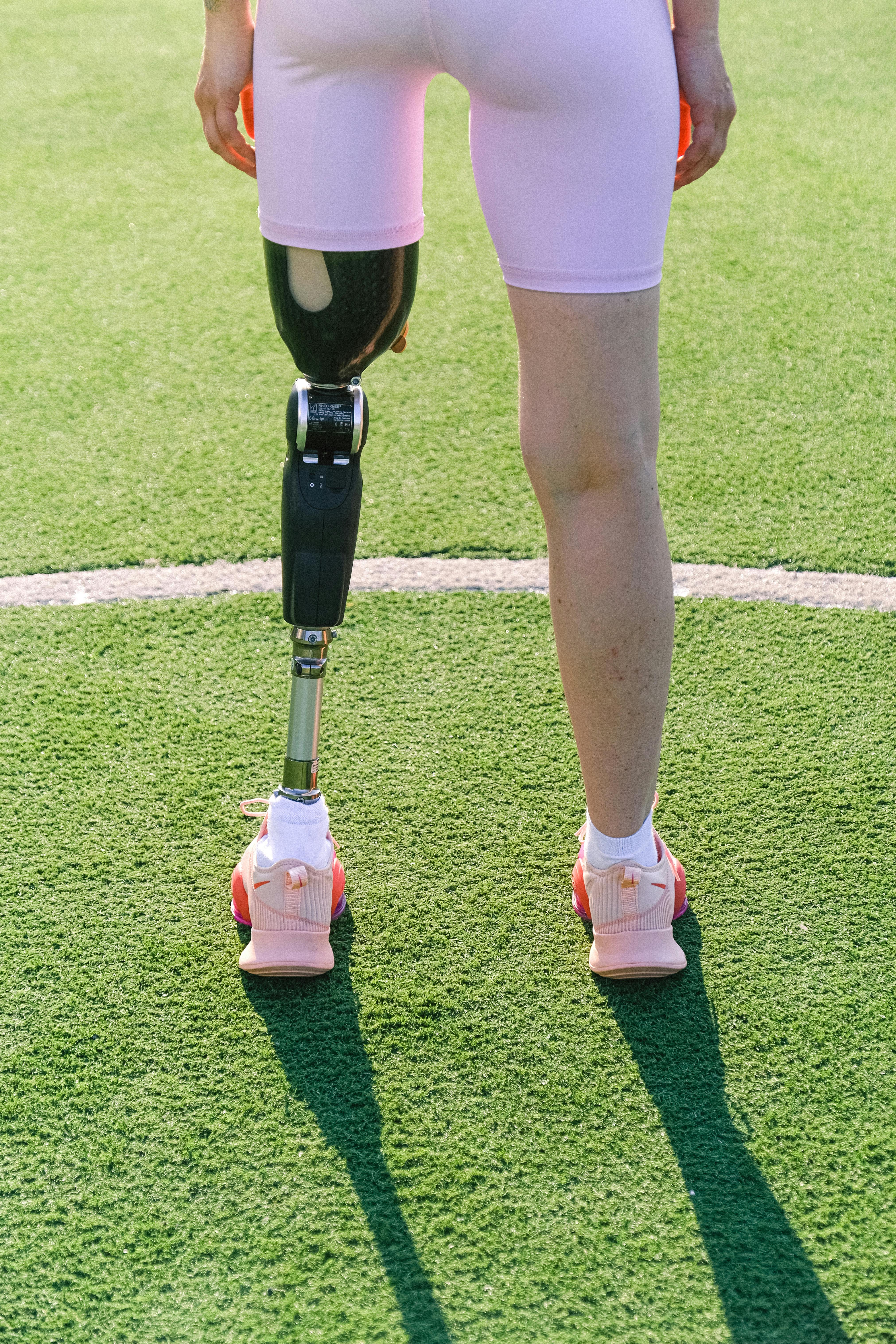 crop sportswoman with prosthesis on stadium