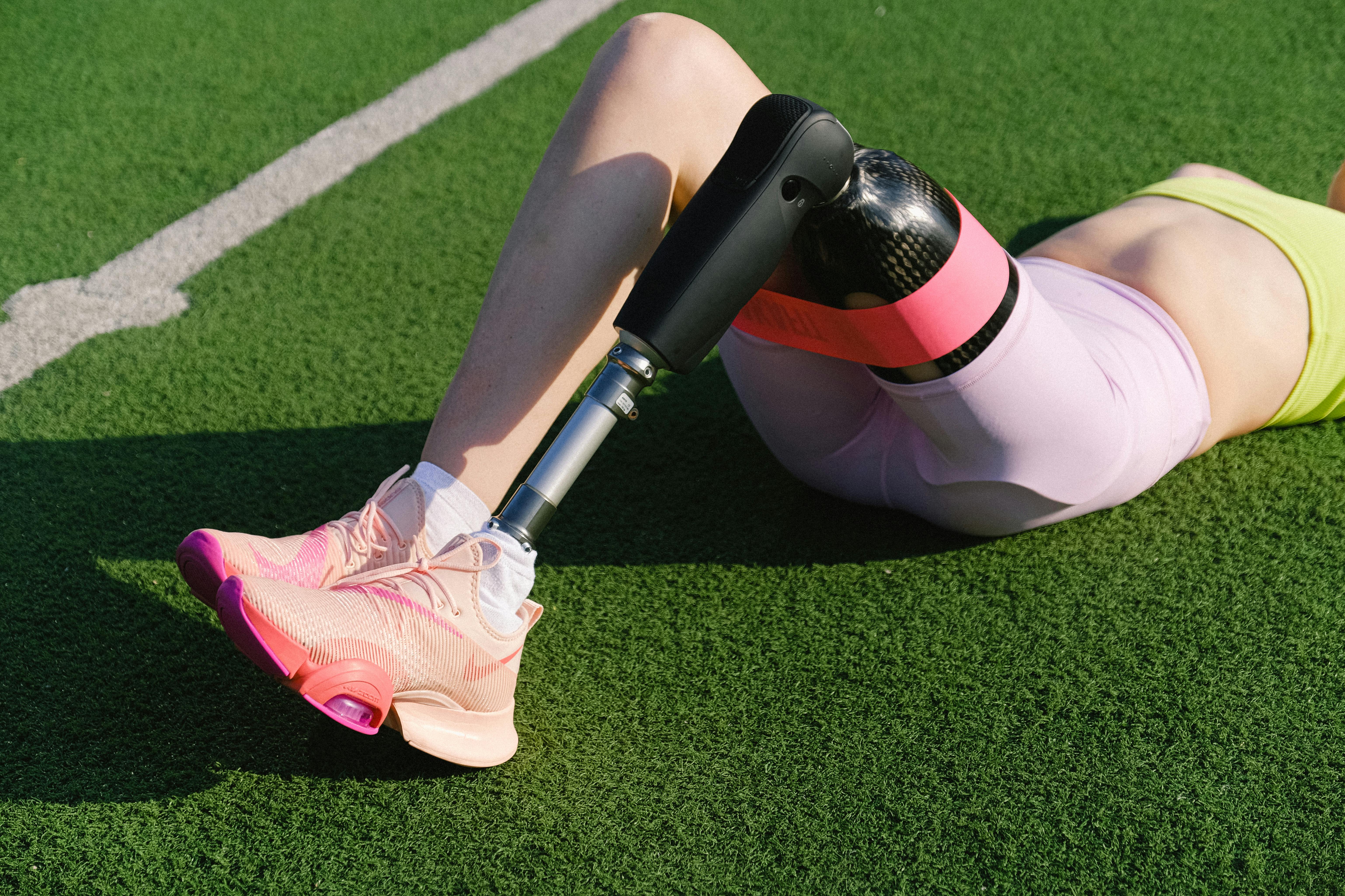 athlete with prosthetic leg lying on grass