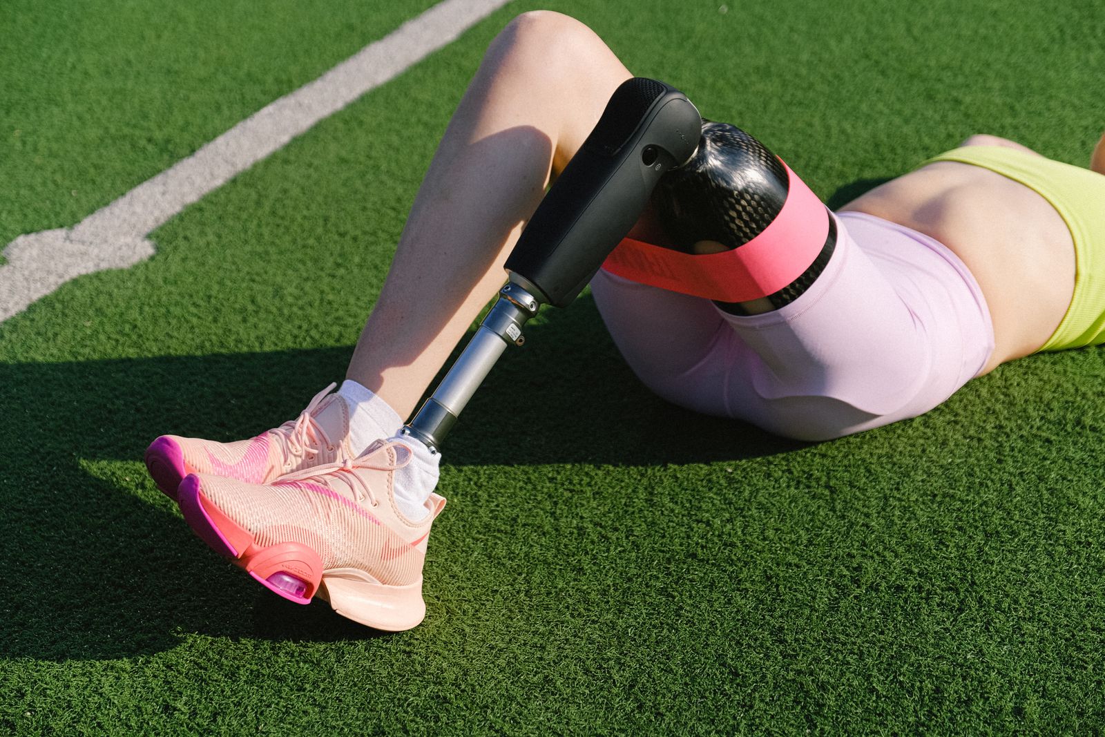 Bright outdoor runner adjusting a knee brace before activity