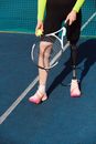Person in Pink Shoes Holding White and Orange Tennis Racket