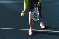 Person in Green Long Sleeve Shirt and Pink Pants Holding Black and White Tennis Racket