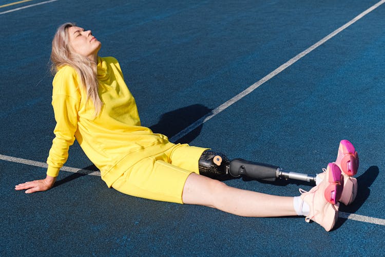 Woman With Prosthetic Leg Lying Down On The Ground