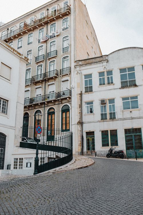 Free Classic European architecture captured along a winding cobblestone street in an urban setting. Stock Photo