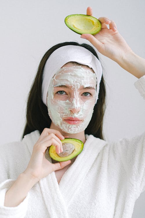 Serious woman with cosmetic product on face