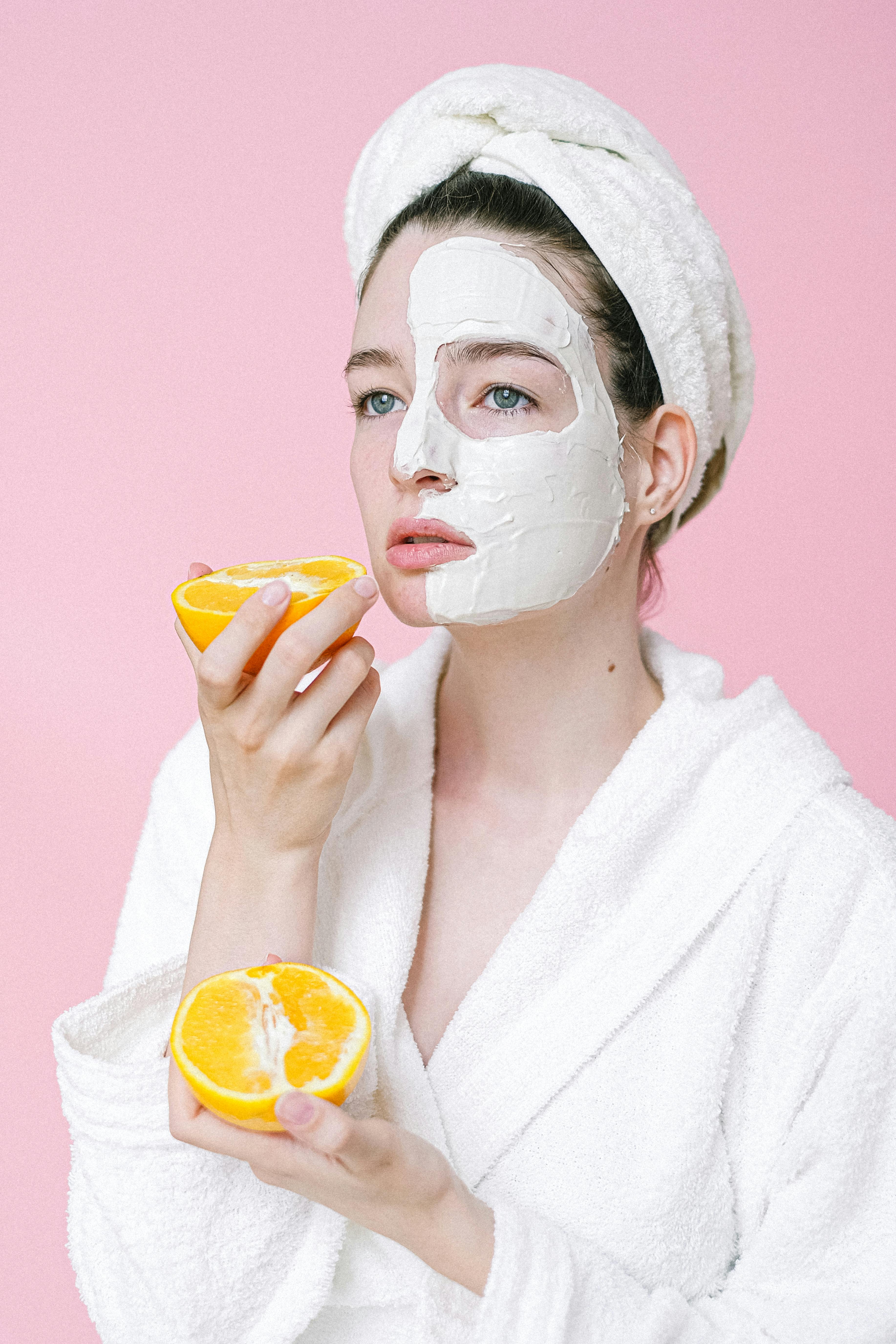 dreamy female with oranges and mask on face
