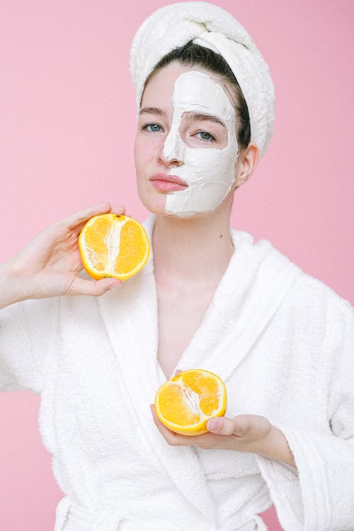 Content woman with facial mask on half of face