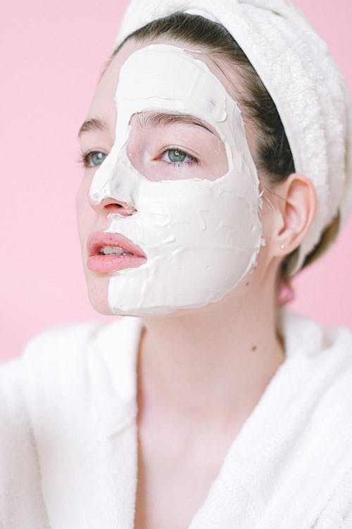 Tender woman with cosmetic mask on face