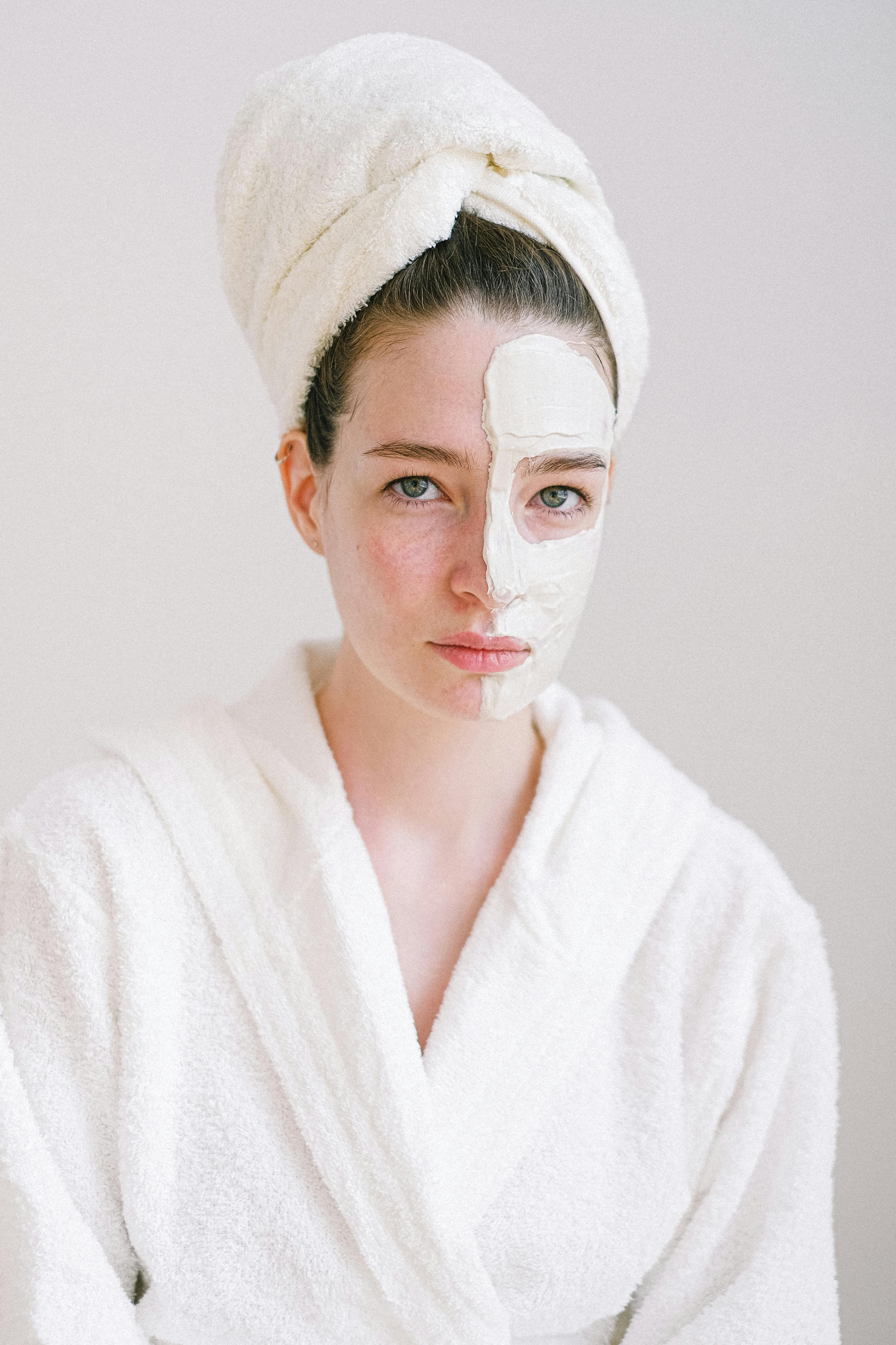 beautiful woman with cosmetic mask on face skin in spa