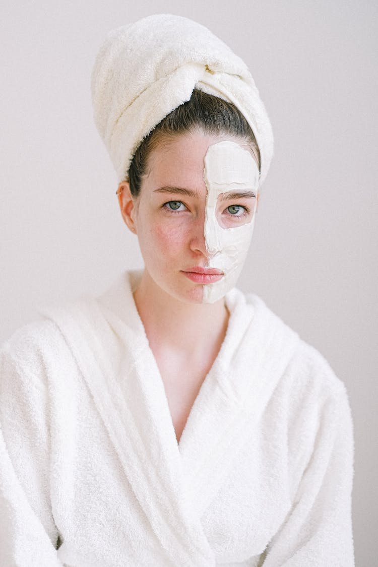 Beautiful Woman With Cosmetic Mask On Face Skin In Spa