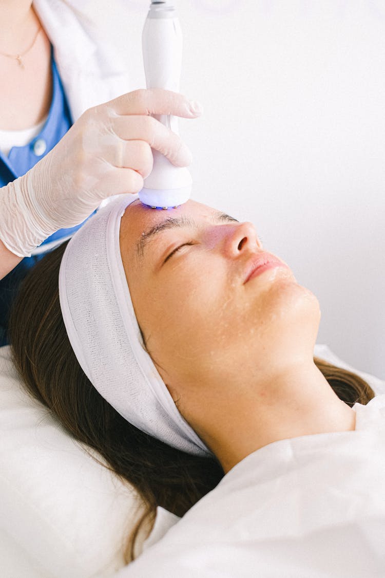 Cosmetician Doing Ultrasonic Face Cleansing For Client