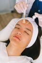 Cosmetician applying cosmetic product on customer face