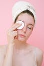 Woman removing eye makeup with cotton pad