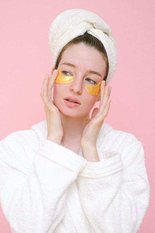 Woman applying eye patches in bathroom