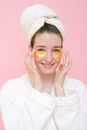 Smiling woman with eye patches touching face