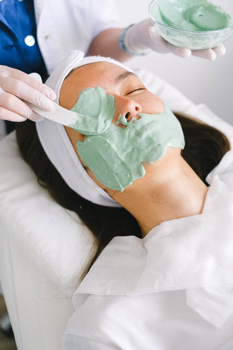 Cosmetician Applying Facial Mask On Client