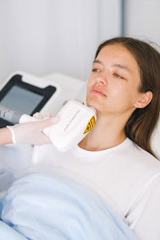 A young woman undergoes a laser facial treatment in a clinical setting, emphasizing modern skincare techniques.