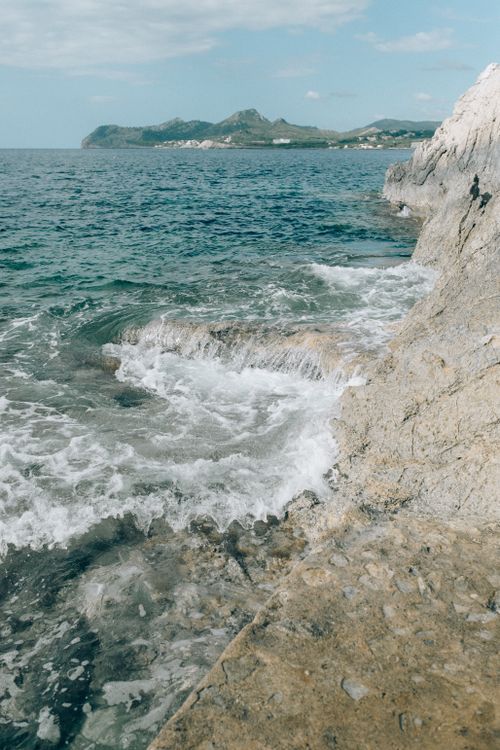 Free A breathtaking view of ocean waves crashing against rugged cliffs, capturing the power of nature. Stock Photo