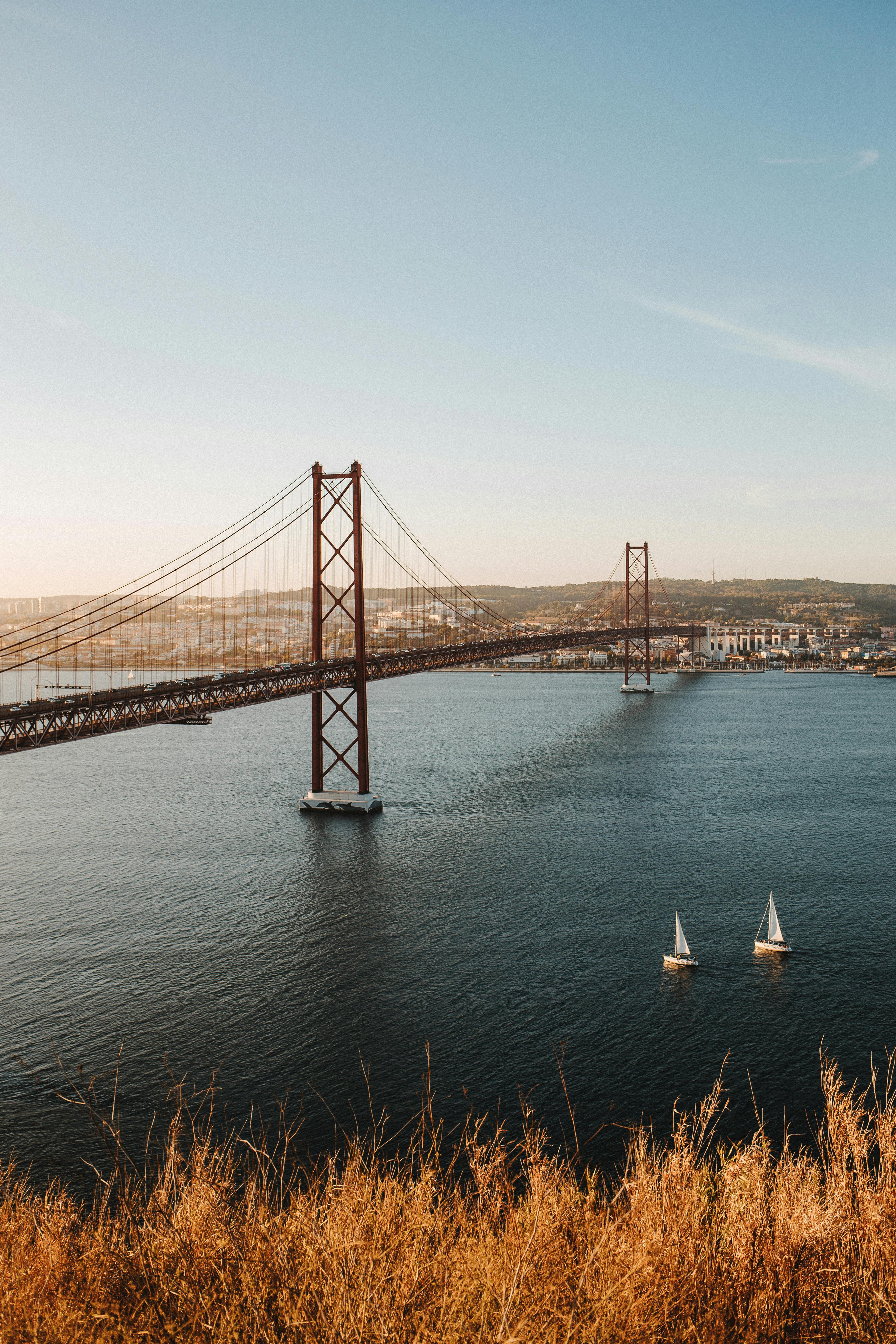 a suspension bridge under the blue sky and white clouds