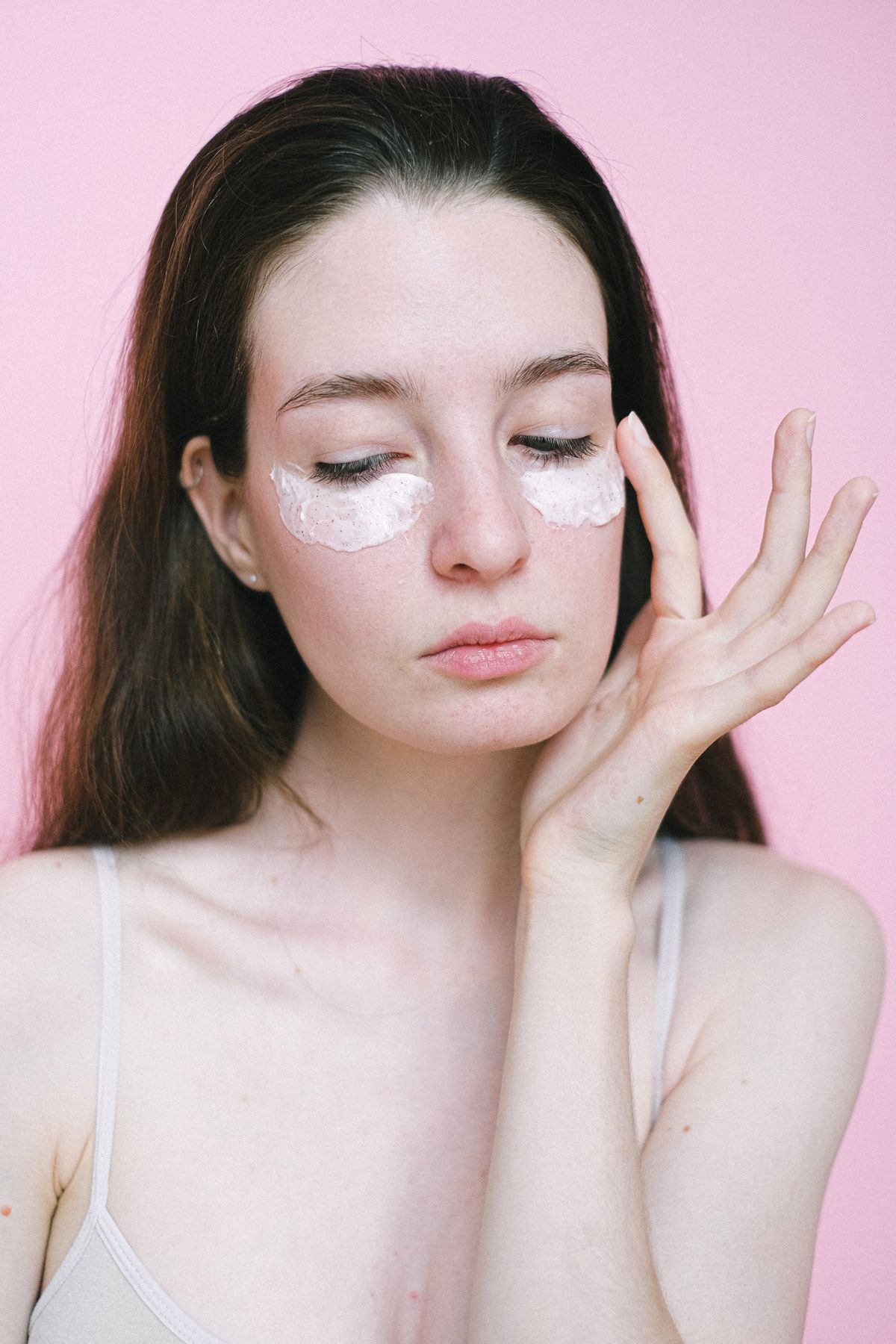 Woman applying moisturising cream under her eyes
