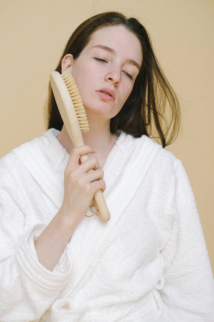 Woman Touching Face With Brush For Dry Massage