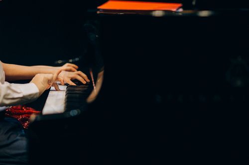 Free A detailed view of hands playing piano keys during a musical performance. Stock Photo