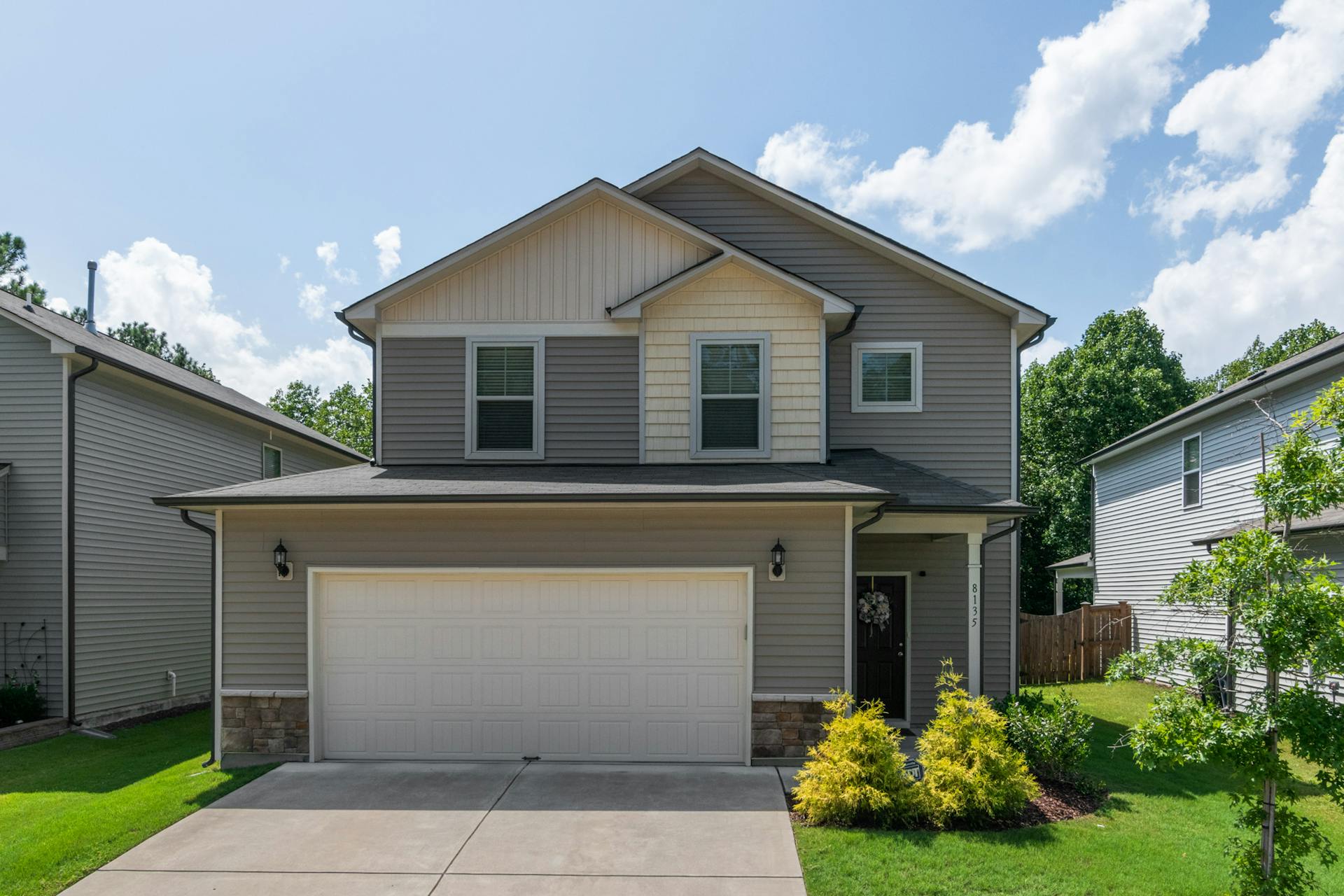 Front view of a modern suburban family home with lush landscaping.