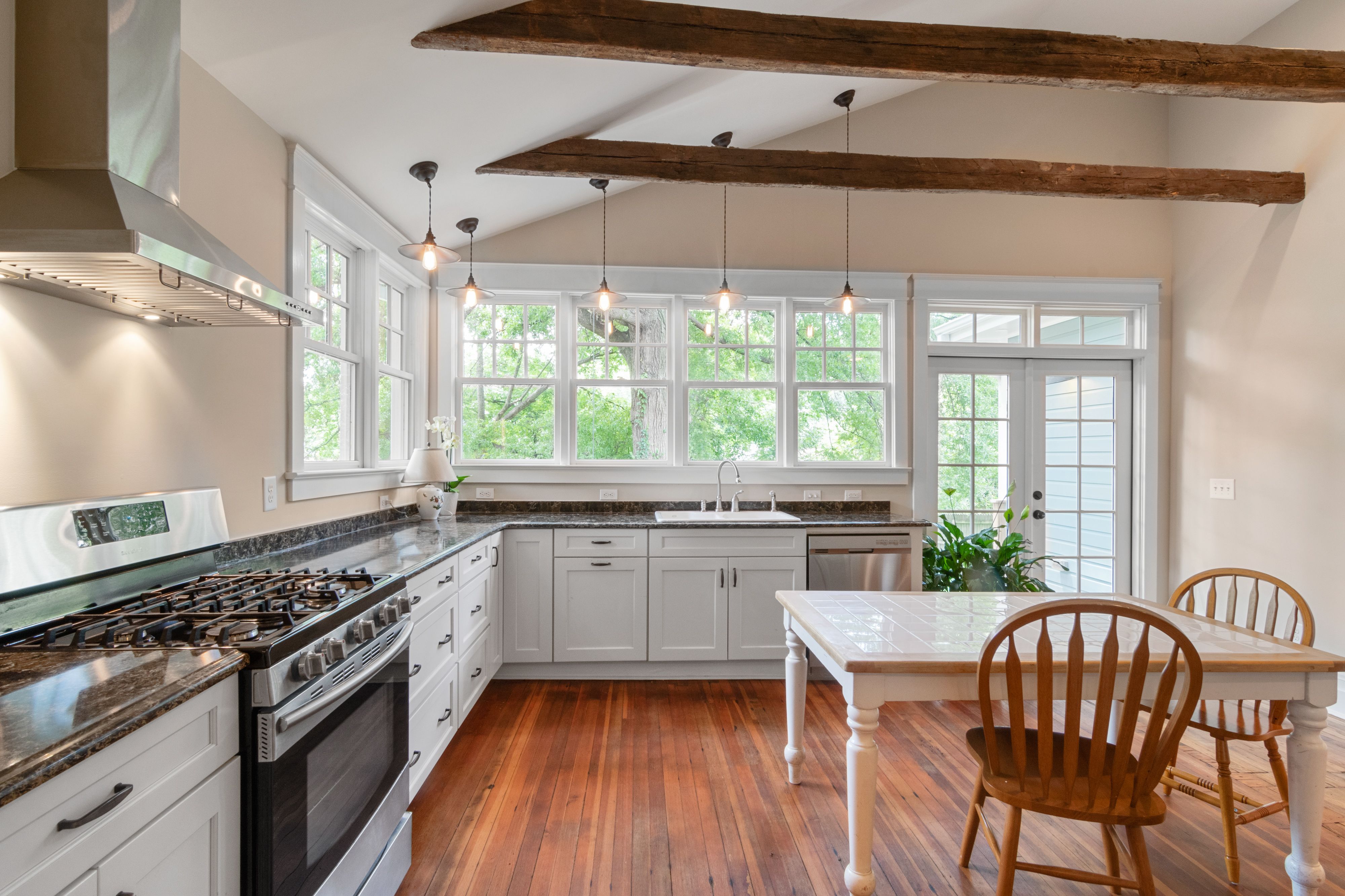 Bright kitchen interior with wooden beams and white cabinetry, natural lighting modernizing a Kitchener, Ontario renovat