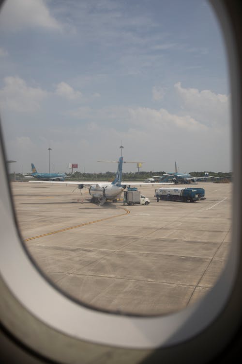View of a White and Blue Airplane Out of a Passenger Plane Window