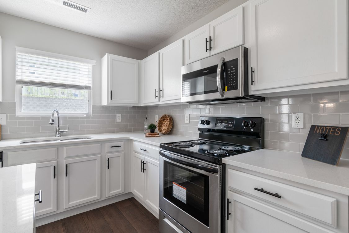 White Wooden Kitchen Cabinet and Black and Silver Gas Range Oven