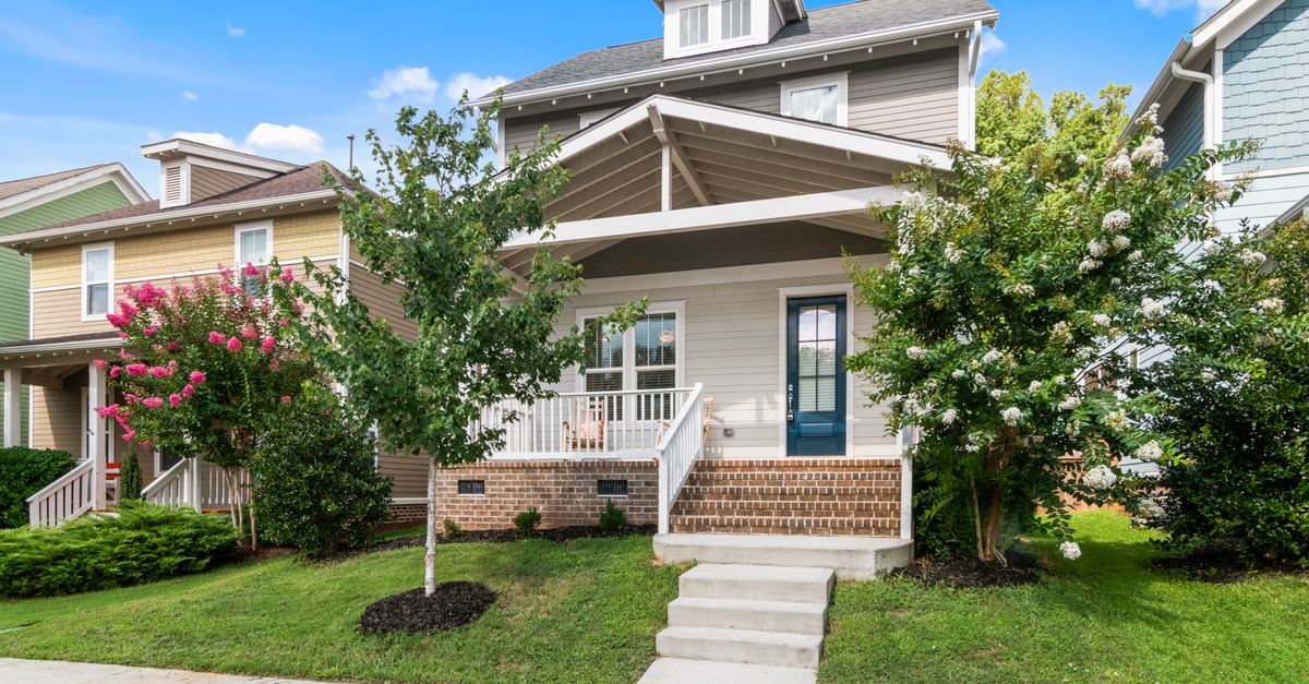 Beautiful suburban home with a landscaped yard and welcoming porch.