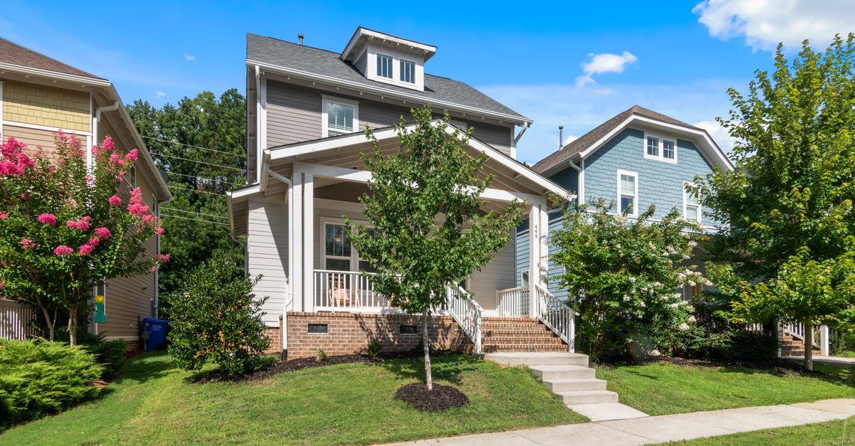 Beautiful suburban home with lush greenery and clear blue sky.