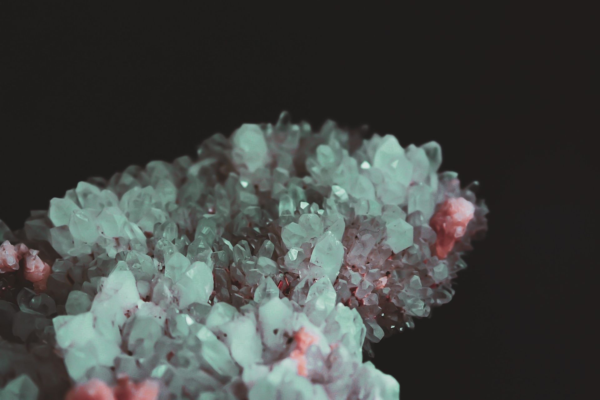 A captivating close-up of translucent quartz crystals with a hint of pink against a dark backdrop.